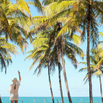 vrouw op strand peace tussen palmbomen